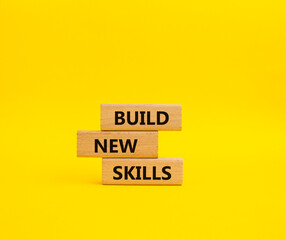 Build New skills symbol. Concept word Build New skills on wooden blocks. Beautiful yellow background. Business and Build New skills concept. Copy space