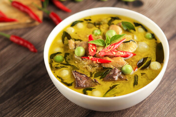 Thai food chicken green curry with coconut curry on dark wooden background. top view