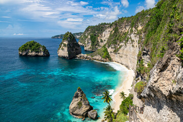 The beautiful sandy beach (Diamond beach) with rocky mountains and clear water in Nusa Penida,...