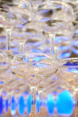 empty champagne glasses in pyramid or tower on table at wedding reception, alcohol bar, catering in restaurant.