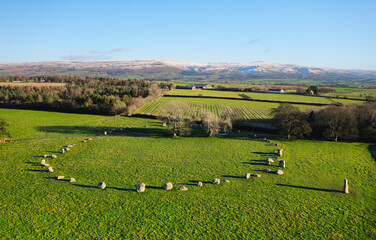Long Meg and Her Daughters stone circle. Prehistoric Neolithic monument. Langwathby, Cumbria, UK. S.E. over Eden Valley to snow covered Pennines