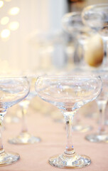 Pyramid of empty champagne glasses against golden bokeh background
