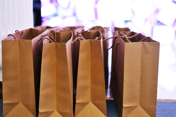 Gifts in craft packages for the participants of the event stand on the floor against the background...