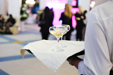 Tray with two glasses of champagne. Waiter holding a tray with glasses of champagne