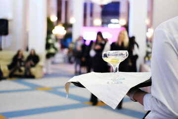 Tray with two glasses of champagne. The waiter serves champagne to the guests of the event