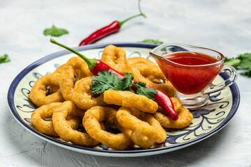 Rings of squid with lemon and sauce on a light background. Snack to beer. banner, menu, recipe place for text, top view