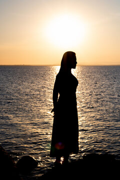 silhouette of woman by sunny and sea