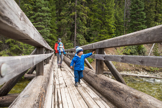 Adventurous mother walks across bridge with her two children
