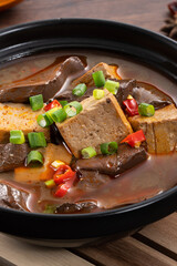 Spicy duck blood jelly soup and stinky tofu with scallion and chili pepper topping.