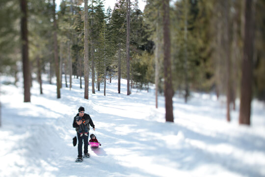 A father snowshoe with an infant and a toddler in the snow covered wilderness of Lake Tahoe, Calfornia.