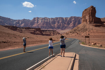 women photographing rocks on the road in Barble Canyon. Arizona.