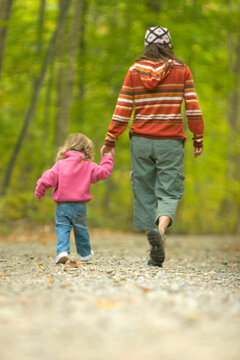 Young woman and child exploring in forest in rural Lake Ossipee, New Hampshire.