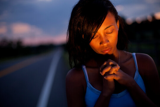 A young woman poses by the side of the road to pray in Butler, Maryland.