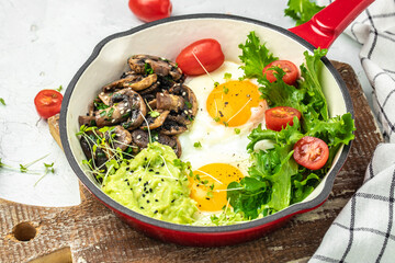 Closeup of tasty fried eggs with avocado and mushrooms. Ketogenic diet. Low carb high fat breakfast. Healthy food concept. place for text, top view.