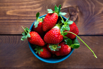 Fresh strawberries in a bowl on a wooden table