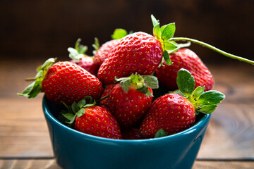 Fresh strawberries in a bowl on a wooden table