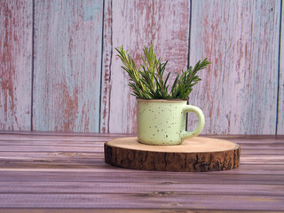 Fresh green rosemary bunch in a small ceramic mug.