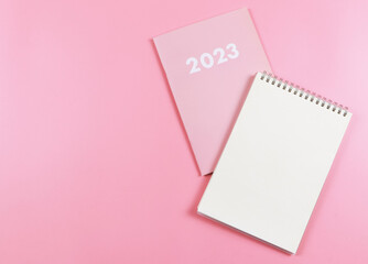 flat lay of blank paper note book on pink diary 2023 on pink  background.