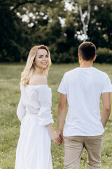 young happy couple running hand in hand in the countryside. young family concept. copy space