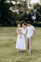 Fototapeta premium attractive young family looking at their daughter. happy childhood young family concept