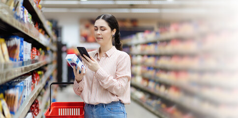 Web banner of online shopping and sales. Smiling caucasian woman scan qr code of product using smartphone. Shelves with food in background. Copy space