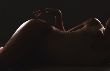 Lingerie, shadow and silhouette of sexy woman relax in erotic, sexual and seductive underwear on dark black background. Sexuality, creativity and body of aesthetic model girl with creative beauty - obrazy, fototapety, plakaty