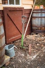 An old gardeners fork standing a soil plot with a sign marked Rhubarb.