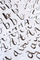 Several white sheets with calligraphic exercises. Calligraphy practice.