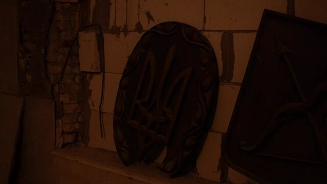Destroyed symbols of Ukraine. Coat of arms of Ukraine in a destroyed house.