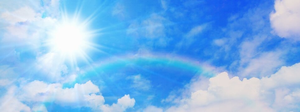 青空に架かる虹と光輝く太陽