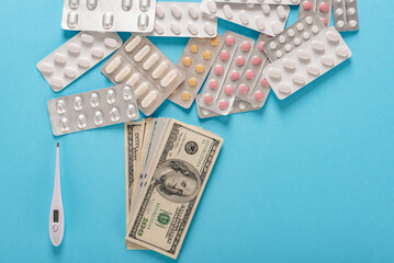 Medical pills, thermometer and dollars money as symbol of high health care costs