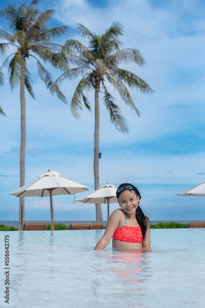 Wall mural Happy girl enjoying summer vacations in a pool. Summer holidays, children's swimming, Pool woman on holidays in tropical resort swimming. summer vacation concept.