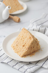 Piece Of Layered Homemade Honey Cake on the white table