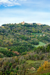 Autumn view of fields  and woods under Belvedere Fogliense, Region Marche of Italy. In the background appears the medieval city of Mondaino