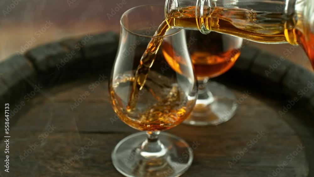 Poster super slow motion of pouring cognac into glass with speed motion. filmed on high speed cinema camera