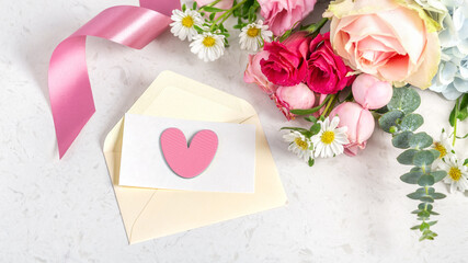 Love letter for valentines day, pastel pink heart and card on envelope with flower on marble background