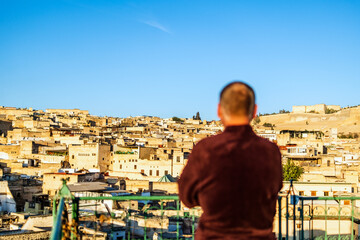 Man on the rooftop enjoying view of Fez old arabic medina, Morocco, Africa