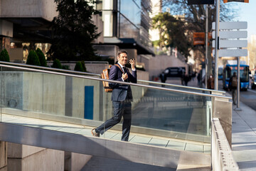 Businessman recording voice message on phone in city