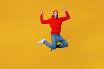 Fototapeta na wymiar Full body young overjoyed excited fun happy caucasian man wear red hoody hat look camera jump high do winner gesture isolated on plain yellow color background studio portrait People lifestyle concept