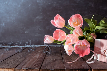 Bouquet of pink tulips on rustic wooden planks. Background still life for mother's day and women's...