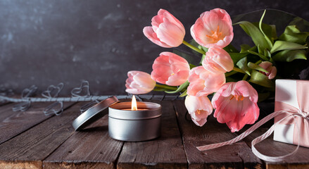 Obraz na płótnie Canvas Bouquet of pink tulips on rustic wooden planks. Background still life for mother's day and women's day concepts.