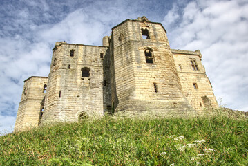 Fototapeta na wymiar warkworth castle with blue sky in the background