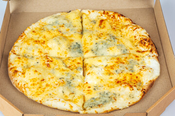 Pizza in a cardboard box isolated on a white background. Top view of pizza packaging. Delicious, juicy, flavorful food. Quick snack. Bad fast food.