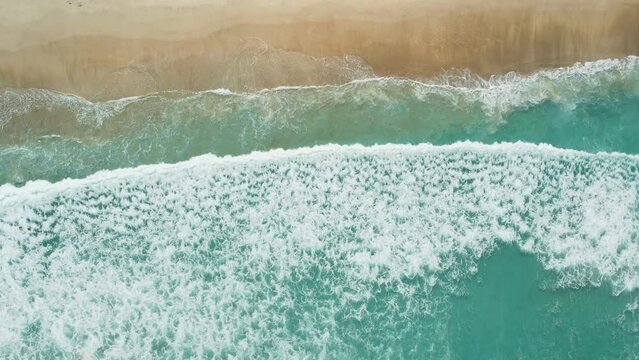 Beach with waves and foam, aerial view. Top view of holiday island