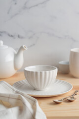 Empty tableware - white plate, a bowl and a cup on wooden table as a background for a dish foodbackground