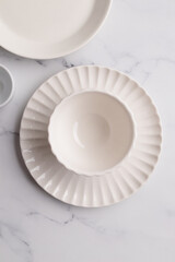 Empty tableware - white plate, a bowl and a cup on white table as a background for a dish foodbackground