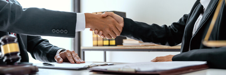 Obraz na płótnie Canvas Lawyer consultant shaking hand with client sign contract agreement document. in law firm. Business meeting Handshake.  