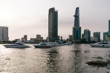 Fototapeta na wymiar HOCHIMINH CITY, VIETNAM - JANUARY 22, 2022: sunset afternoon looking over district 1 ho chi minh city with Bitexco building and other high-rise buildings. There are cruise ships on the river