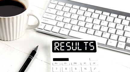 RESULTS text on calculator with keyboard and coffee