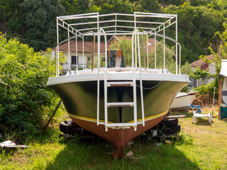 Sea motor boat on a ground stabilized by car tyres front view